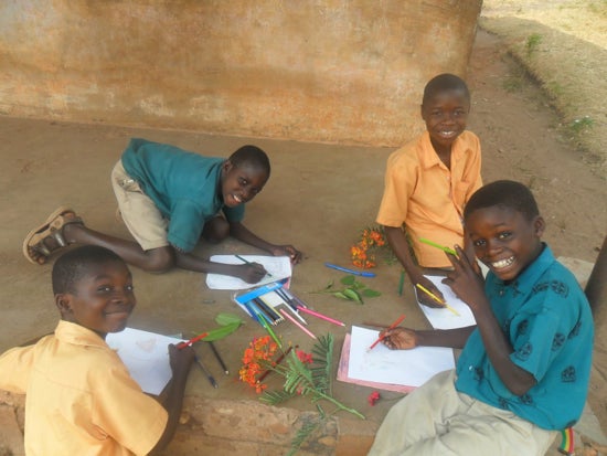 A group of four students coloring flowers 